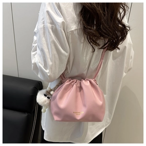 Pink pleated cloud bag detail with gold lettering and soft white plush charm ball
