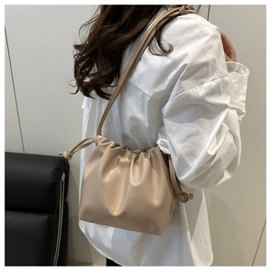 Detailed view of beige pleated cloud bag with soft PU leather and gold fashion logo