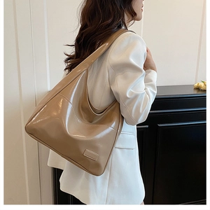 Chic khaki high-gloss hobo bag worn by model, showing large capacity and shiny finish
