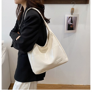 Detailed view of large white glossy faux leather hobo tote bag on model for casual commuting