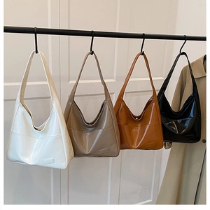 Four retro hobo shoulder bags in white, khaki, brown, and black hanging on a display rack