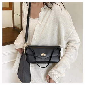 Nahaufnahme der minimalistischen schwarzen Leder-Baguette-Tasche mit goldener Schnalle