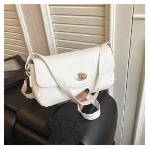 Close-up of white flip-top handbag with gold twist lock and a sleek textured finish
