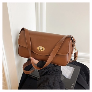 Detail of the brown faux leather handbag showing the gold oval turn-lock and fine texture