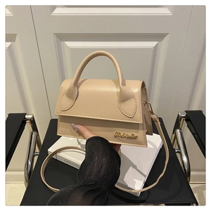 Détail du sac à main beige en cuir PU avec logo doré et bandoulière réglable chic