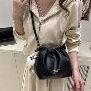 Chic black pleated cloud bag with white plush charm and adjustable crossbody strap
