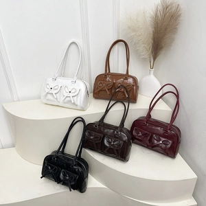 Fashionable multi-pocket underarm handbags in five colors shown on a display stand