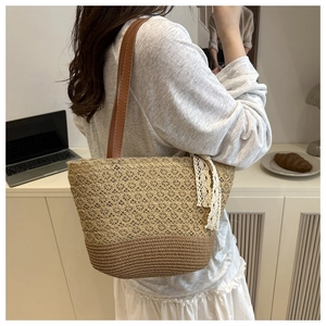 Detail of hollow floral weave pattern on straw tote bag with brown leather shoulder strap