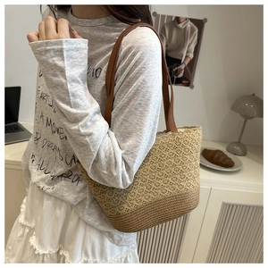 Detailed view of hollow woven pattern and leather straps on straw tote beach bag