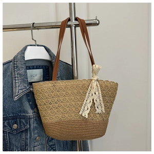 Detail of bohemian lace patchwork and straw woven texture on a summer tote bag