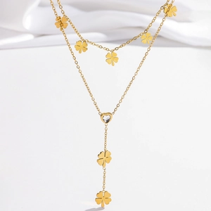 Elegant gold layered Y-necklace with flat clover charms and a crystal heart pendant