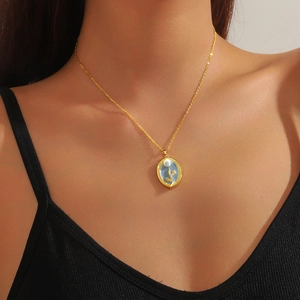 Vintage goldene ovale Tulpen-Halskette mit blauem Inlay und Perle an einem Model