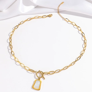 Collana con chiusura OT dorata e ciondolo in madreperla bianca su elegante sfondo di seta