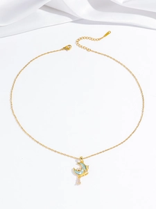 Detail of gold moon pendant with zircon stones and blue droplet on white silk backdrop