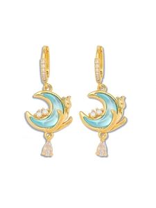 Detail of gold moon earrings with blue enamel, zircon hooks, and teardrop crystals