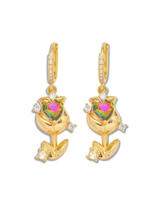 Détail de boucles d'oreilles tulipes dorées avec cristal de cœur et zircons pavés
