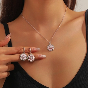 Parure collier et boucles d'oreilles fleur rose avec perle et cristaux sur modèle