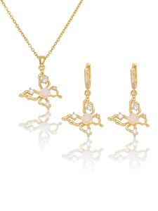 Détail de la parure papillon dorée avec fleur blanche et accents de zircon cubique