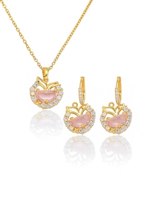 Detailed close-up of mermaid tail jewelry set with pink stones and gold plating