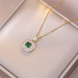Gold necklace with square emerald zircon pendant and crystal halo on champagne velvet