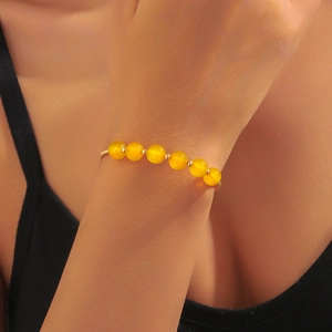 Bracciale rigido aperto dorato minimalista con sette perle di agata occhio di gatto gialle