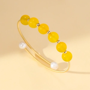 Elegante bracciale rigido dorato con perle di agata gialla e perle bianche fini