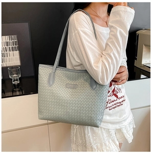 Close-up of light blue large tote bag featuring classic woven texture and shoulder strap