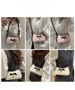 Detail of bow-knot shoulder bag featuring heart charm and floral jacquard pattern