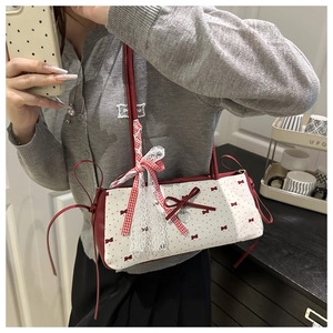 Detail of red and white bow shoulder bag with lace trim and heart pendant charms