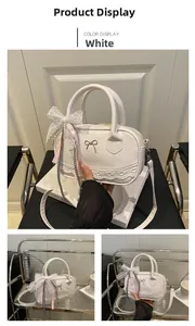 Close-up of white lace bowling bag with pink ribbon bows and gold metal accent
