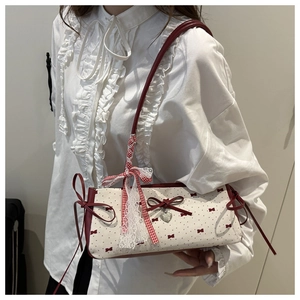Close-up of red bow details and polka dot canvas on stylish French baguette bag
