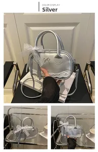 Detail of silver metallic handbag with white lace trim and cute bow charm attachment