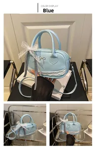 Detail of blue lace Boston bag with metallic bow and heart lace trim on base