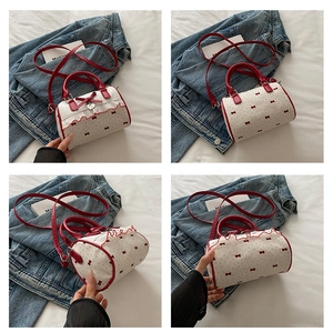 Detailed views of a white Boston bag featuring red bows, heart charms, and ruffled edges