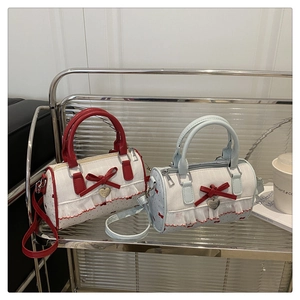 Detail of Boston cylinder bags with bow accents, polka dots, and heart pendants
