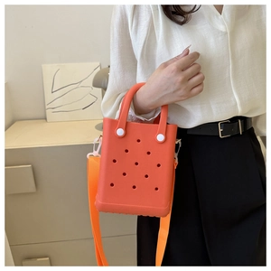 Detail einer leuchtend orangefarbenen EVA-Strandtasche mit Löchern und Schultergurt