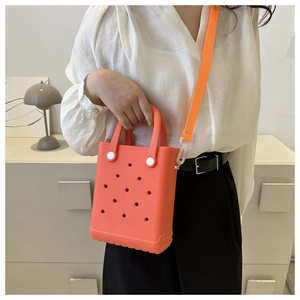 Detail der leuchtend orangefarbenen EVA-Strandtasche mit Lochmuster und Trageriemen