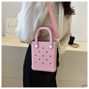 Detail der rosa EVA-Tasche mit dekorativen Löchern und verstellbarem Textilschultergurt