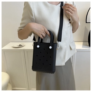 Detail der kreativen schwarzen EVA-Tasche mit Lochmuster und Nylon-Schultergurt