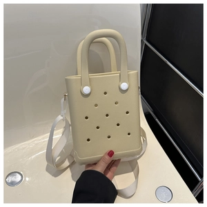 Detail der cremefarbenen EVA-Tasche mit runden Perforationen und Stoff-Schultergurt