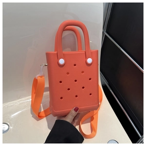 Detailansicht der orangefarbenen EVA-Tasche mit Lochdesign und passendem Schultergurt