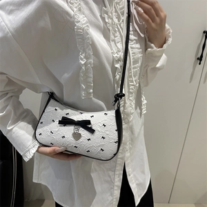 Sac croissant chic à motifs nœuds et breloque cœur sur fond de dentelle blanche