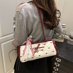 Contrast canvas shoulder bag with red bow design and heart charm accessory