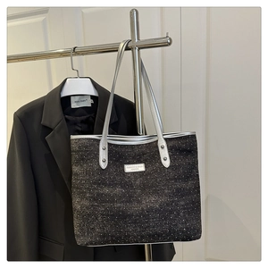 Detail of sequined denim tote bag with silver leather straps and metallic accents