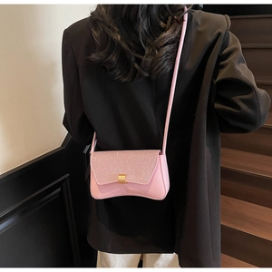 Détail du sac baguette à paillettes roses avec boucle dorée et bandoulière fine