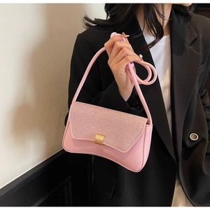Détail du sac baguette rose avec rabat scintillant en strass et boucle dorée chic
