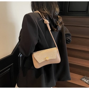 Détail du sac brillant à bandoulière nouée sur des marches avec blazer noir