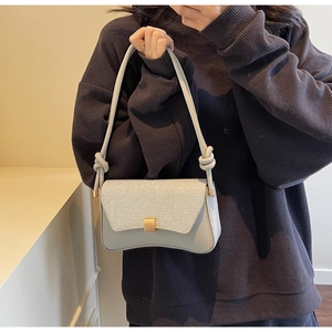Détail du sac à bandoulière bleu clair avec rabat pailleté argenté et boucle dorée