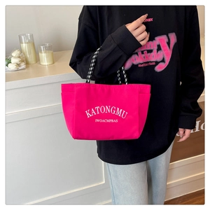 Detail of fuchsia nylon tote bag with polka dot rope handle and side pockets