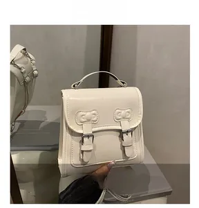 Vue détaillée du sac vintage blanc crème avec nœuds décoratifs et boucle métallique